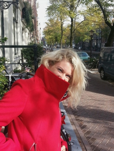 Frau in rotem Mantel im Herbst in Amsterdam Lachen Freude